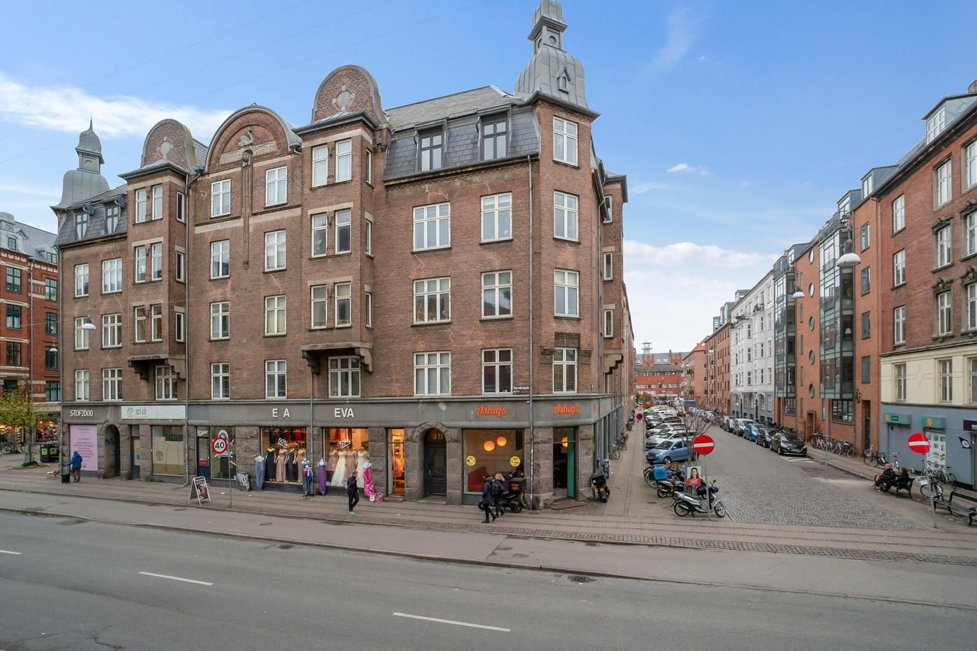 Erhvervsandel med hjørnebeliggenhed i Nørrebro med butikker og cykler langs gaden