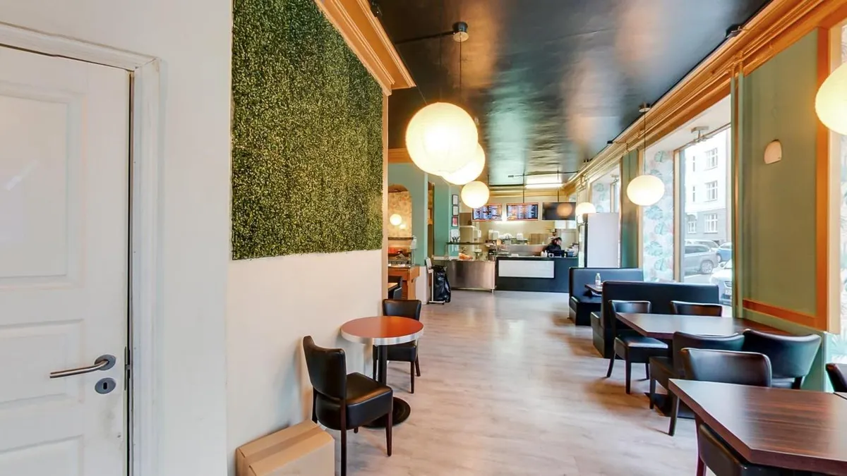 Forretningslokale med møbler og plantevæg, højt loft, moderne design og lyse gulve i hjertet af Nørrebro