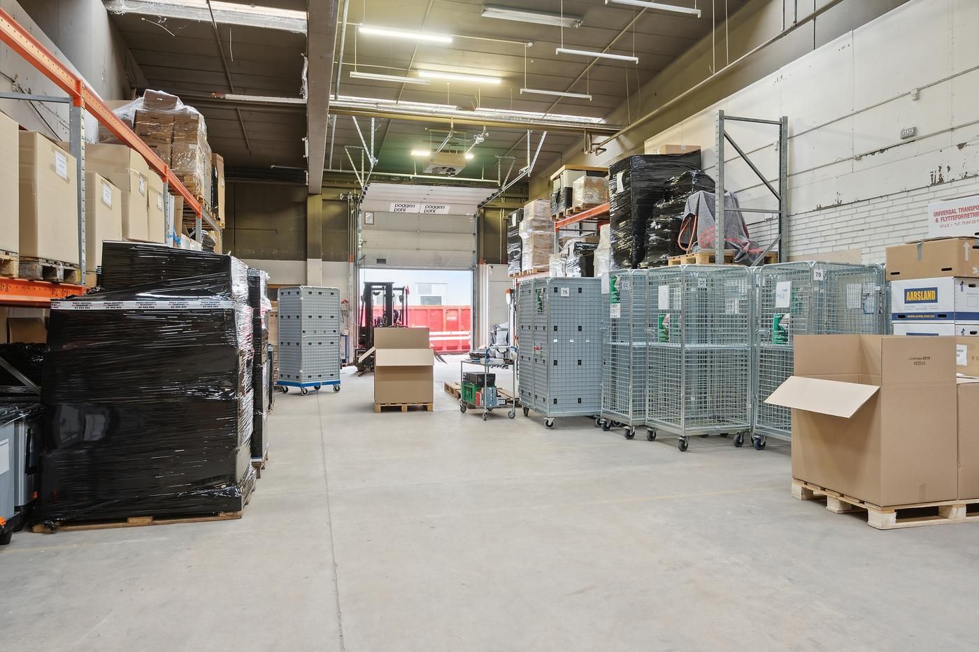 Lager med mange kartoner, et stort antal emballagematerialer og flere stålkasser.