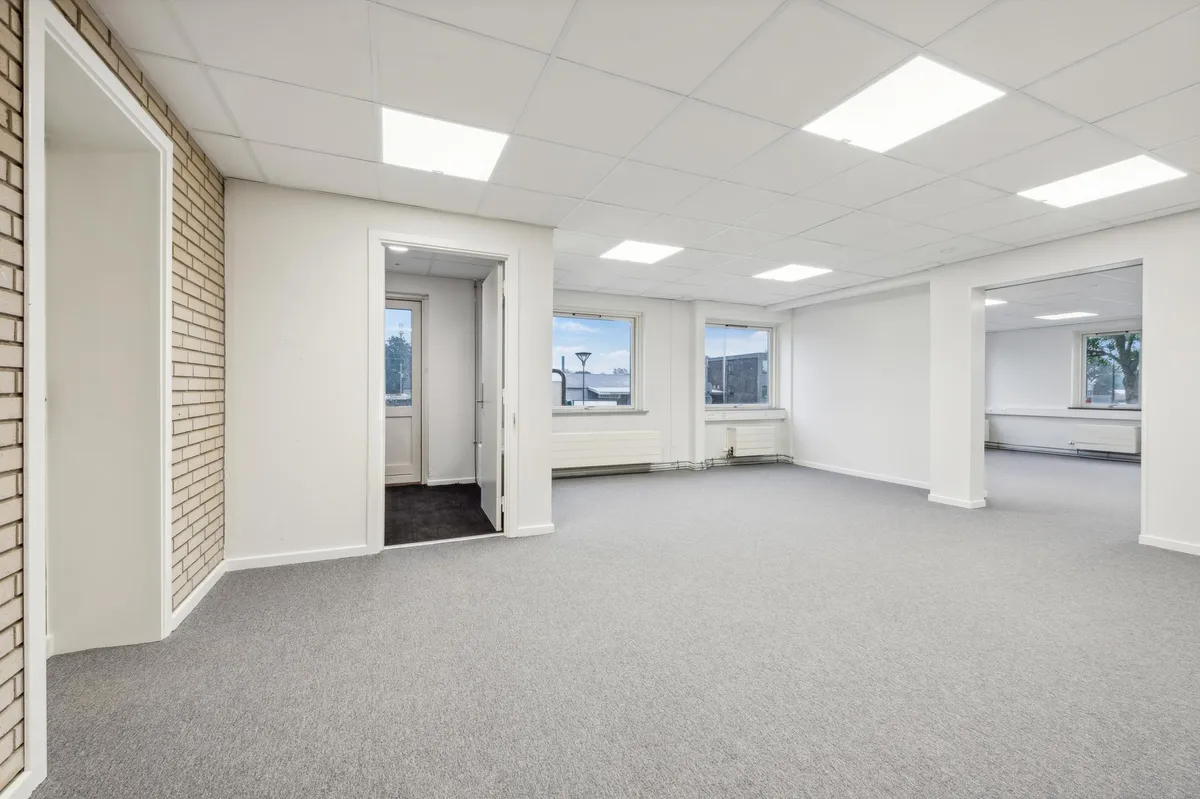 Lagerlokaler med højt til loftet og lyse vinduer med udsigt til byen og træer