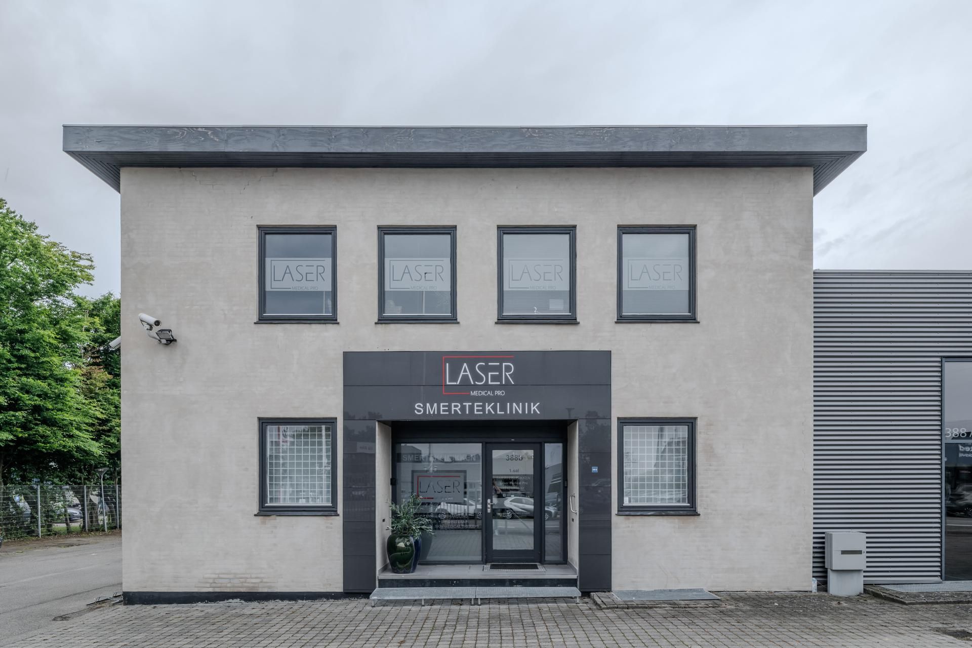 Laser Medical Pro Smerteklinikken med glasvinduer og indgangsdør, der er beskyttet af en glasdør og gulvplade, der er