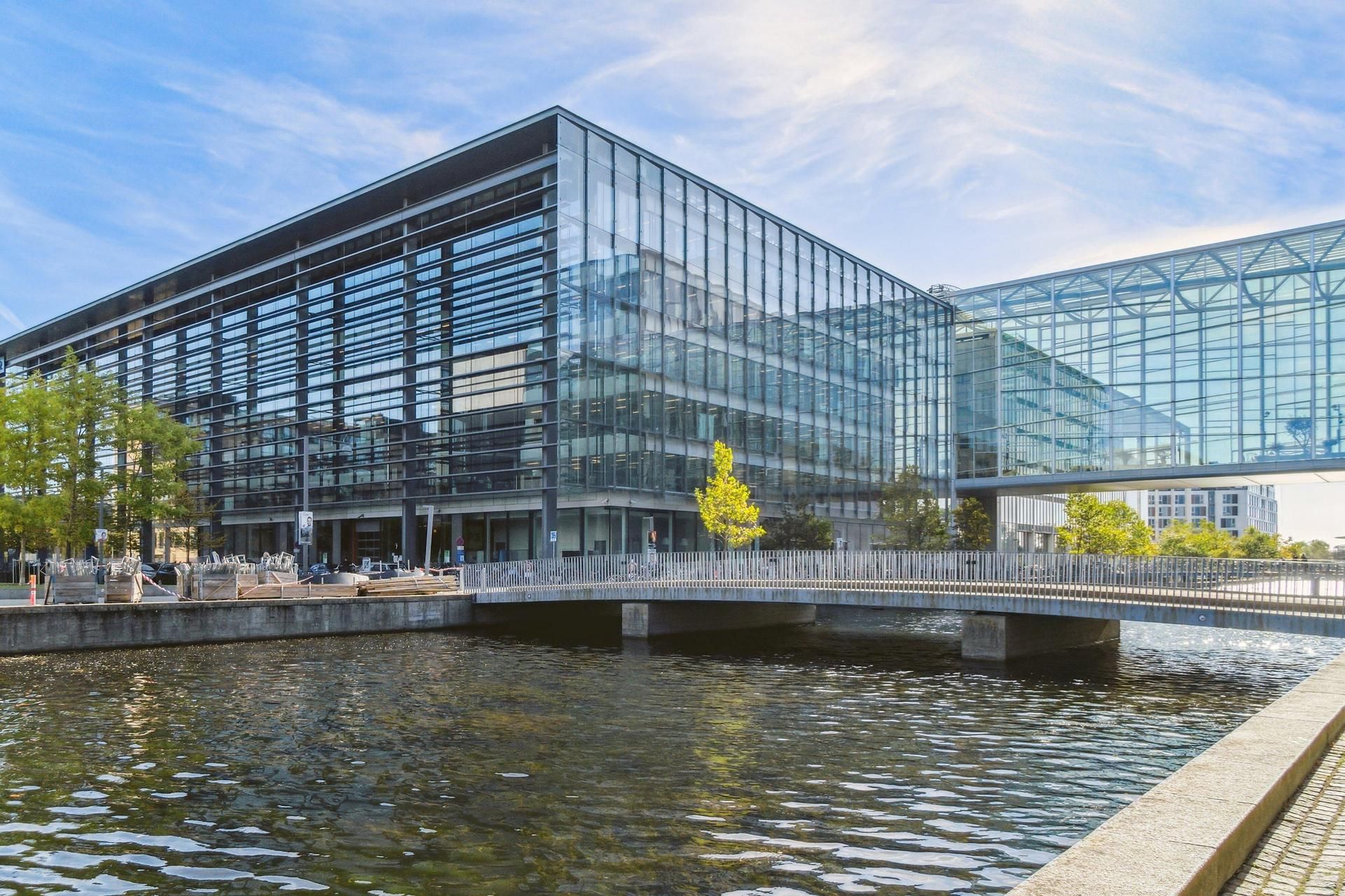 Glass facadeer og stålkonstruktioner af DR-bygningen med bro over vandet og parkområder