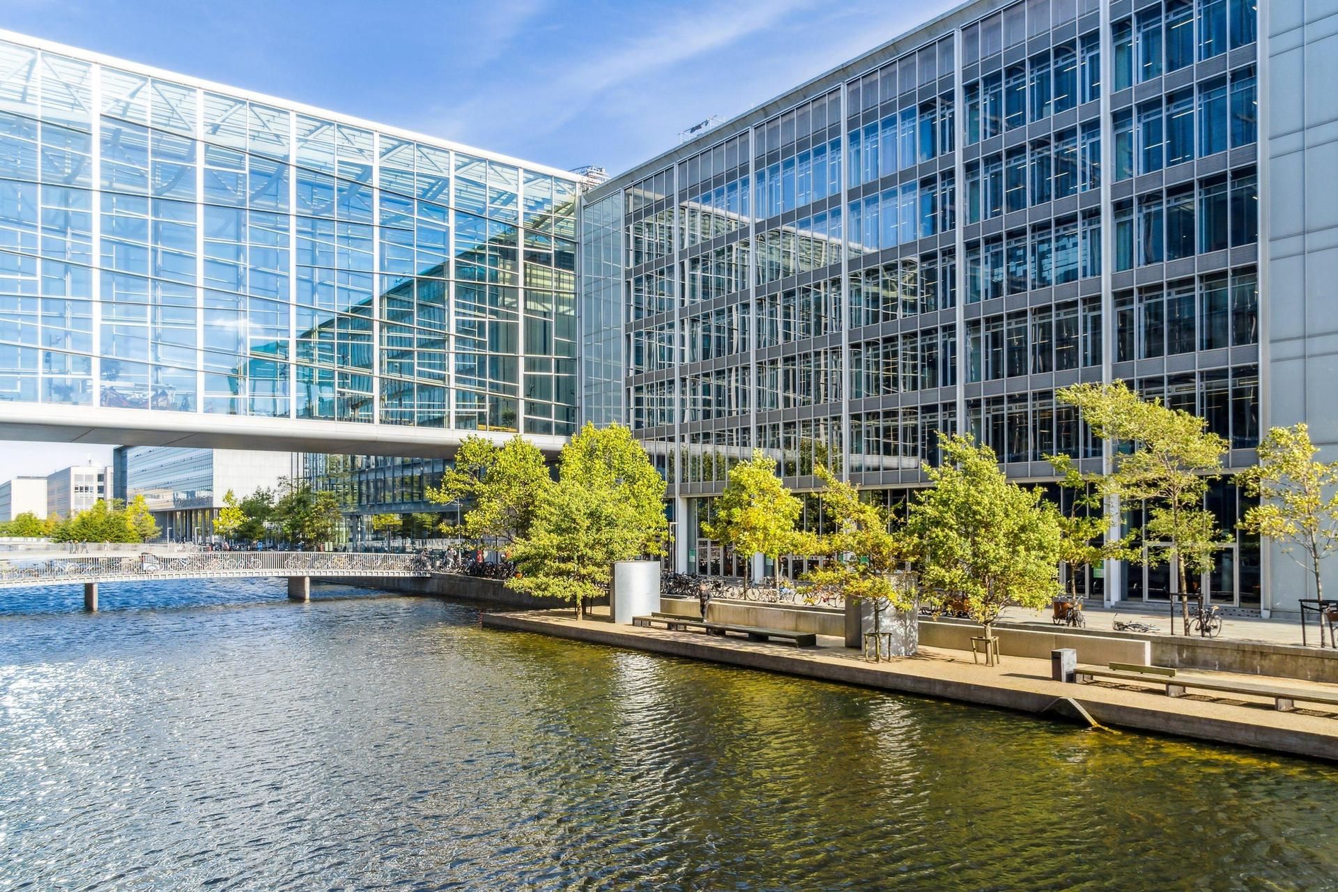 Moderne bygning med glasfasade, træer og vandløb i nærheden, fuld service, elevator, udsigt over Amager Fælled, beliggende