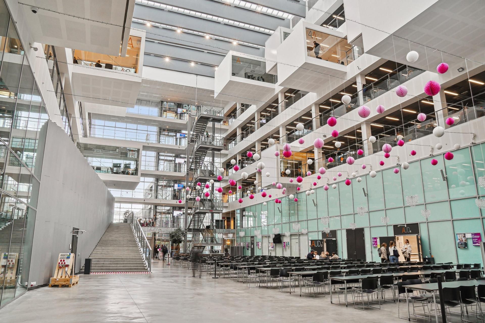 Det store DR-hovedkvarter har et indre område med møbelet og pinke og hvide balloner i loftet. En stor trappe i midten af