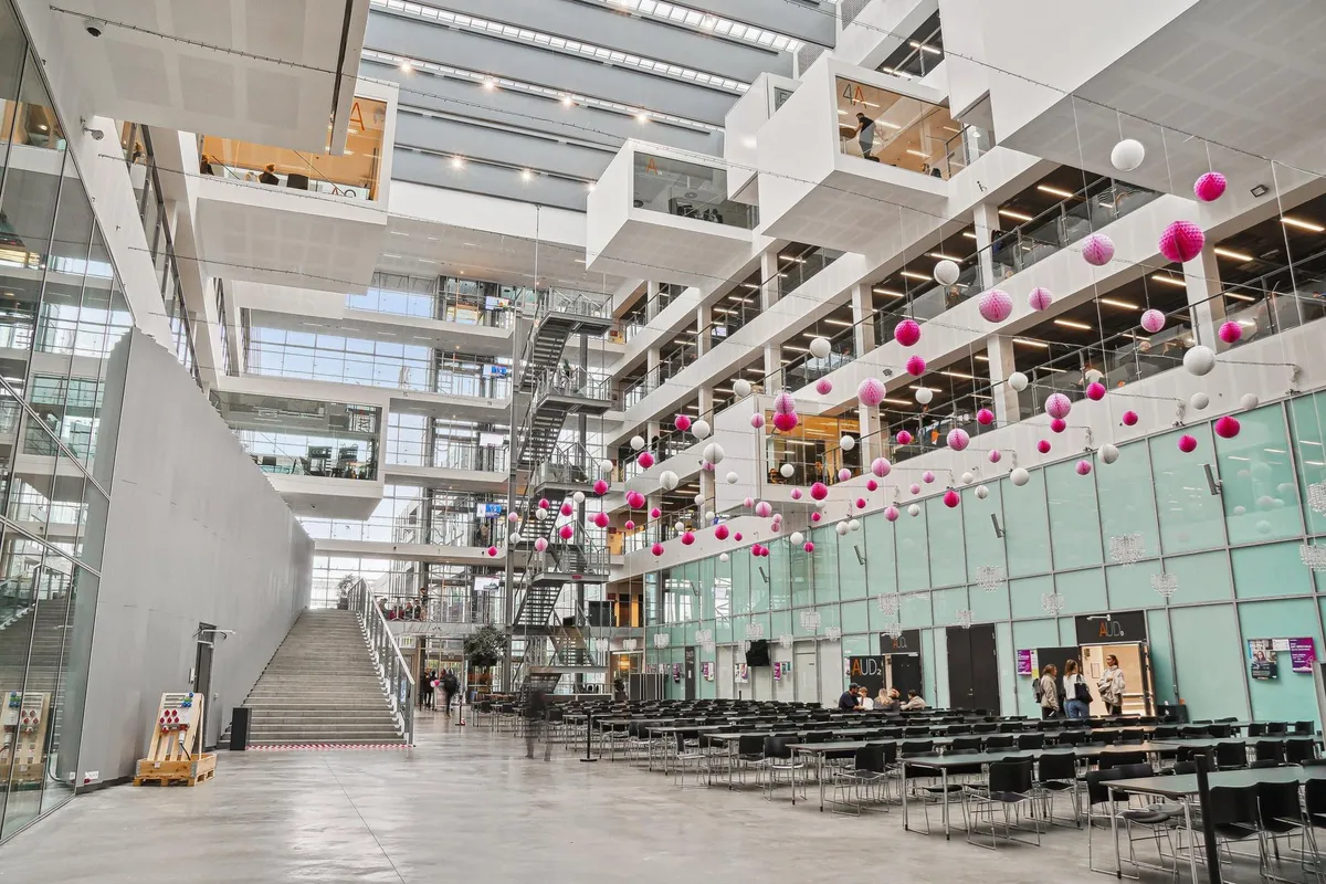 Det store DR-hovedkvarter har et indre område med møbelet og pinke og hvide balloner i loftet. En stor trappe i midten af