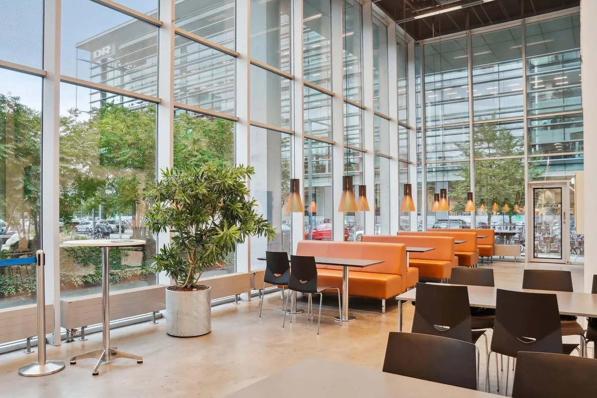 Indvendig i DR-bygningen er der moderne møbler og lyse lamper, hvilket skaber en komfortabel og funktionel atmosfære