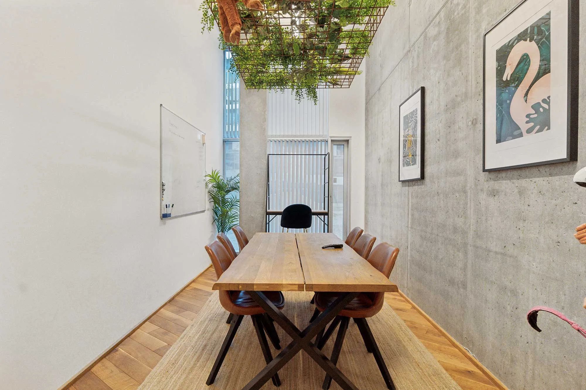 Lejlighed med masser af lys og lysegulve samt et stort, træbord med læderstole og krydsben