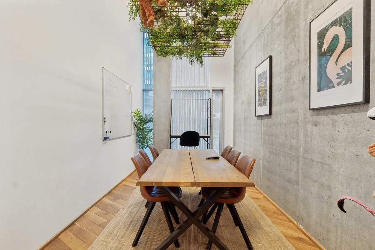 Lejlighed med masser af lys og lysegulve samt et stort, træbord med læderstole og krydsben