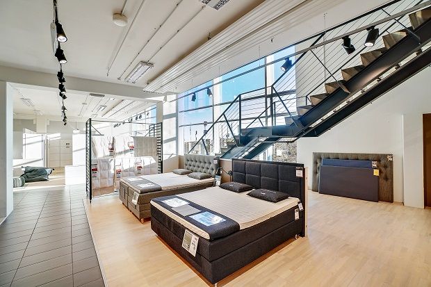 Lyst og moderne møbelforretning med udstille bed, tæpper og ståltrapper på 903 kvm i Sønderborg