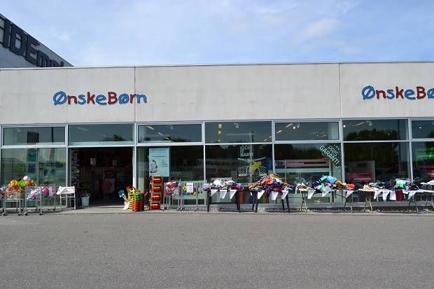 En OnskeBorn butik med legetøj og tøj i vogne udenfor og store vinduer med udstilling af varer