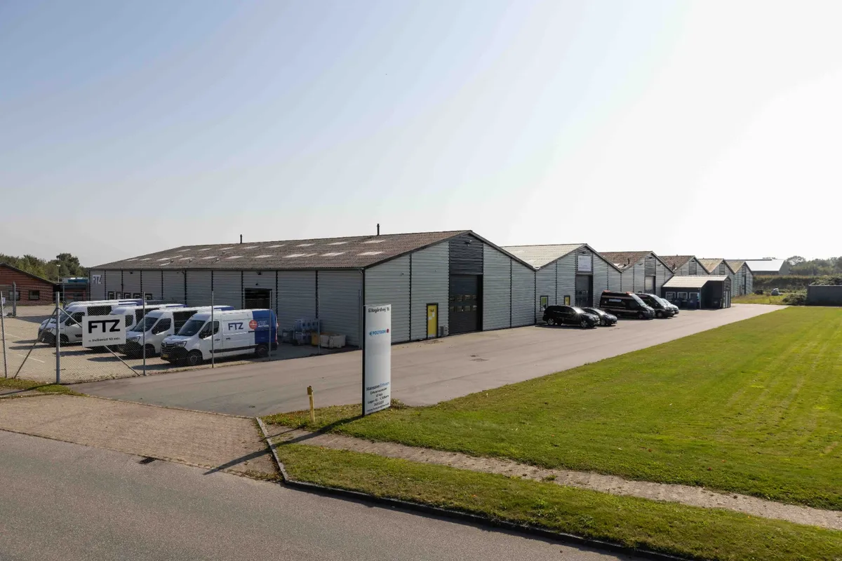 Ledige lagermoduler med forskellige størrelser, fra 42 til 850 kvm, til leje. Parkeringsplads med biler og lastvogne.