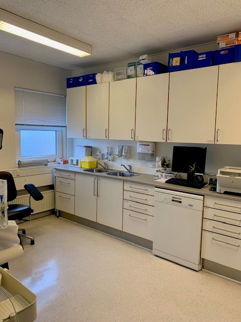 Moderne lyse lokaler med nye gulve og nymalede overflader, hvor en computer, printer, og skrivebord er placeret på et