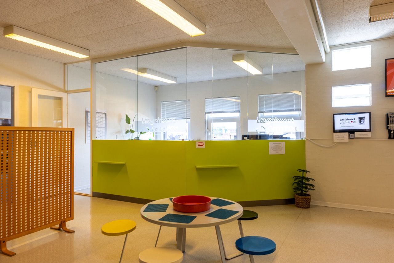 Lyse lokaler med gulve og nye malede vægge, moderne møbler og grønne planter.