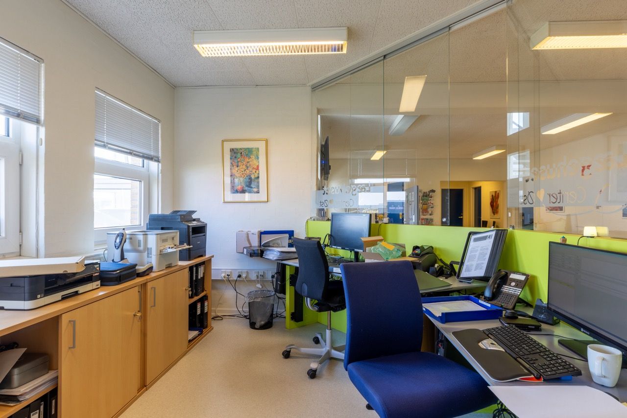 Kontor med moderne møbler, højteknologisk udstyr og lyse lokaler med vinduer og lysekroner