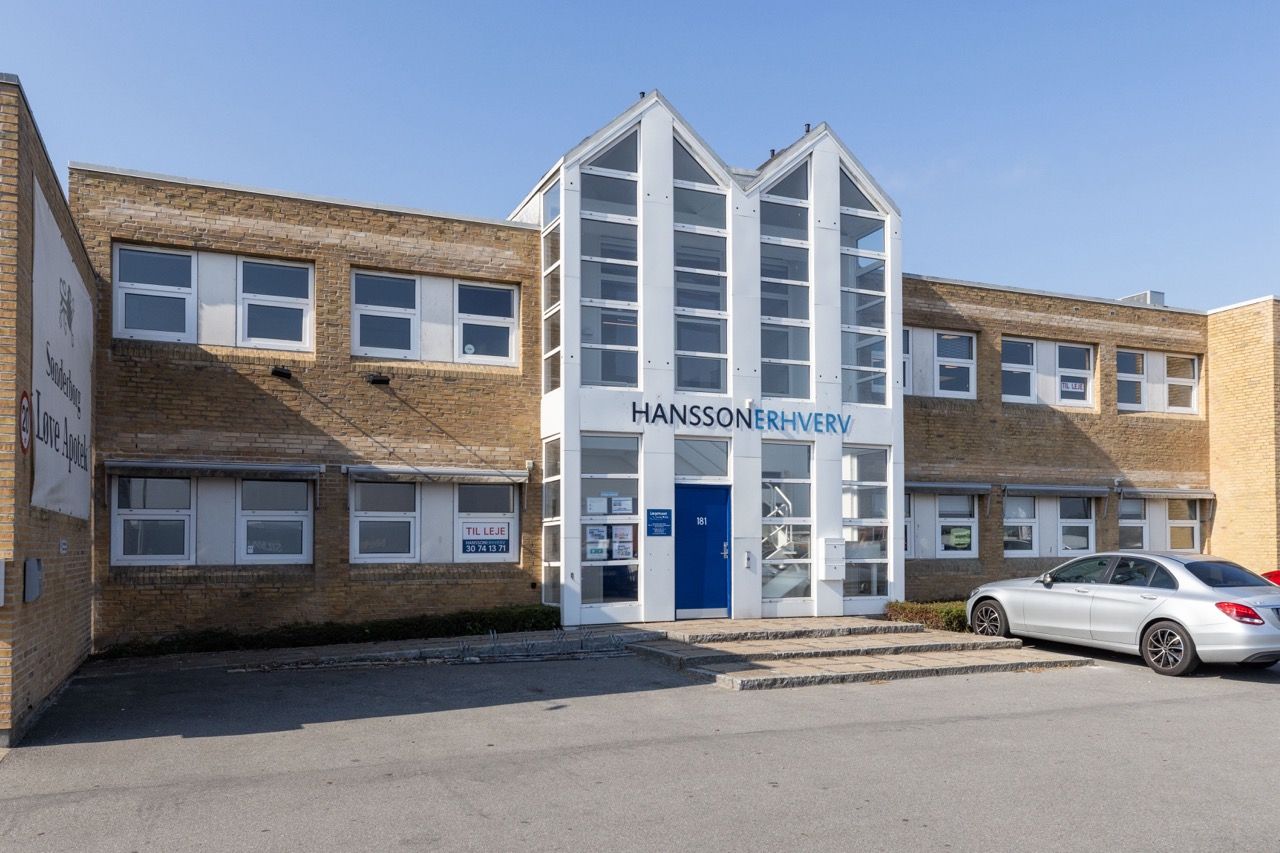 Hansson Erhverv i Rødovre. En nyrenoveret bygning med moderne lyse lokaler og nye gulve. En parkeringsplads foran med en
