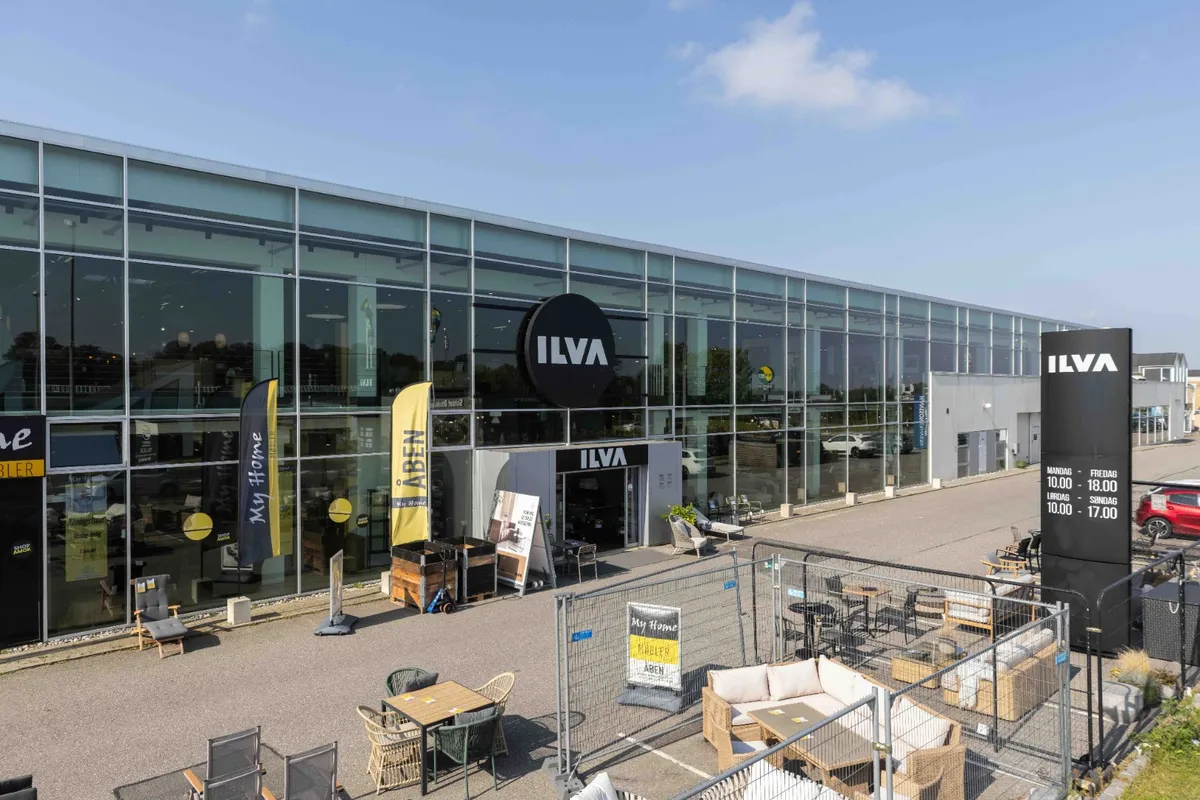 Ilva My Home butik med store glasvinduer og en stor facade med Ilva logoet i sort og hvidt, udenfor er der borde og stole