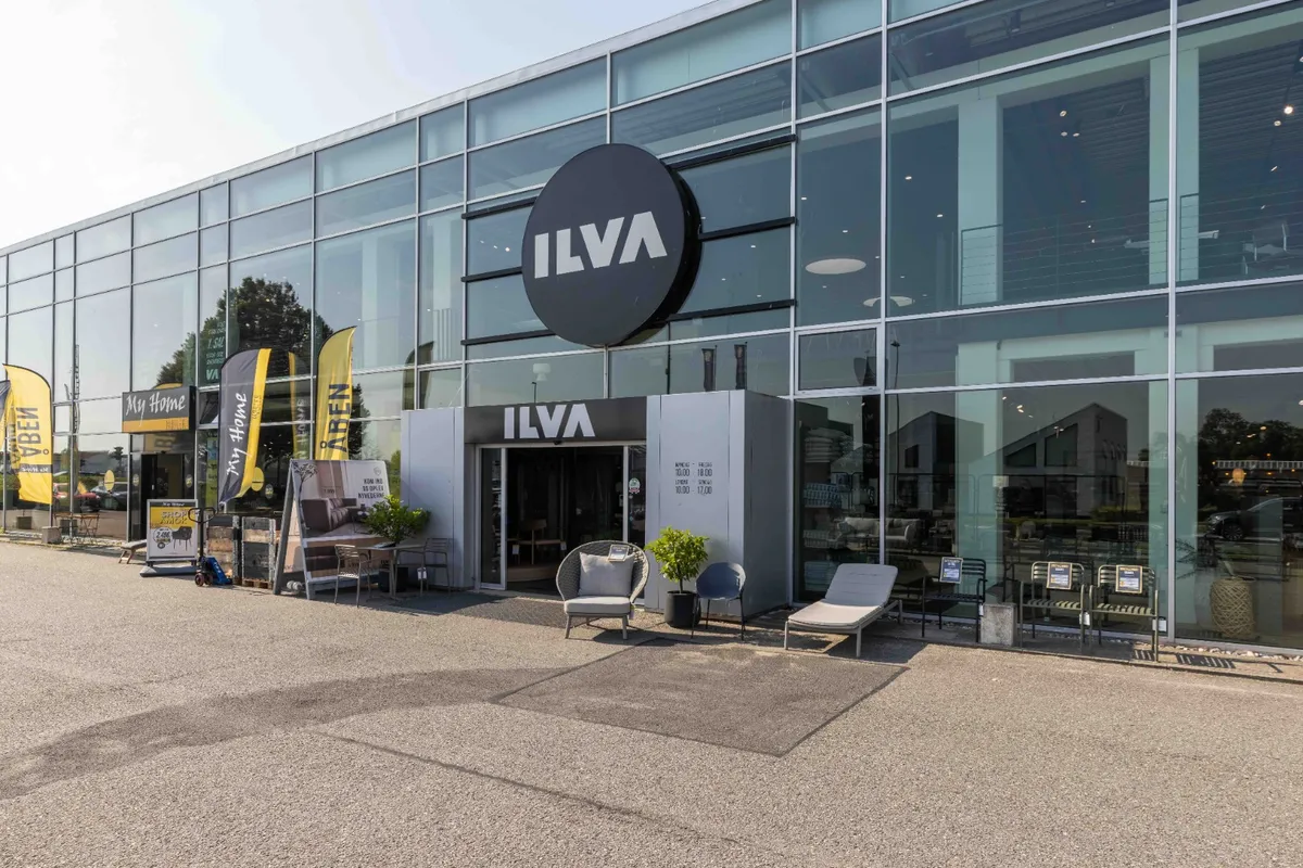 ILVA butik med moderne design, store glasvinduer og udendørs møbler og plantepoter foran døren.