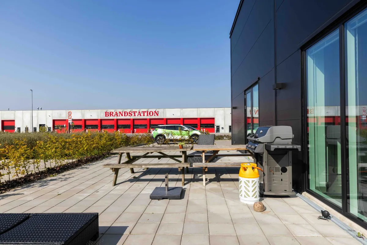 Lejlighed med haveterrasse og grill ved Brandstation, hvor et grønt bilparkeret parkeret foran bygningen