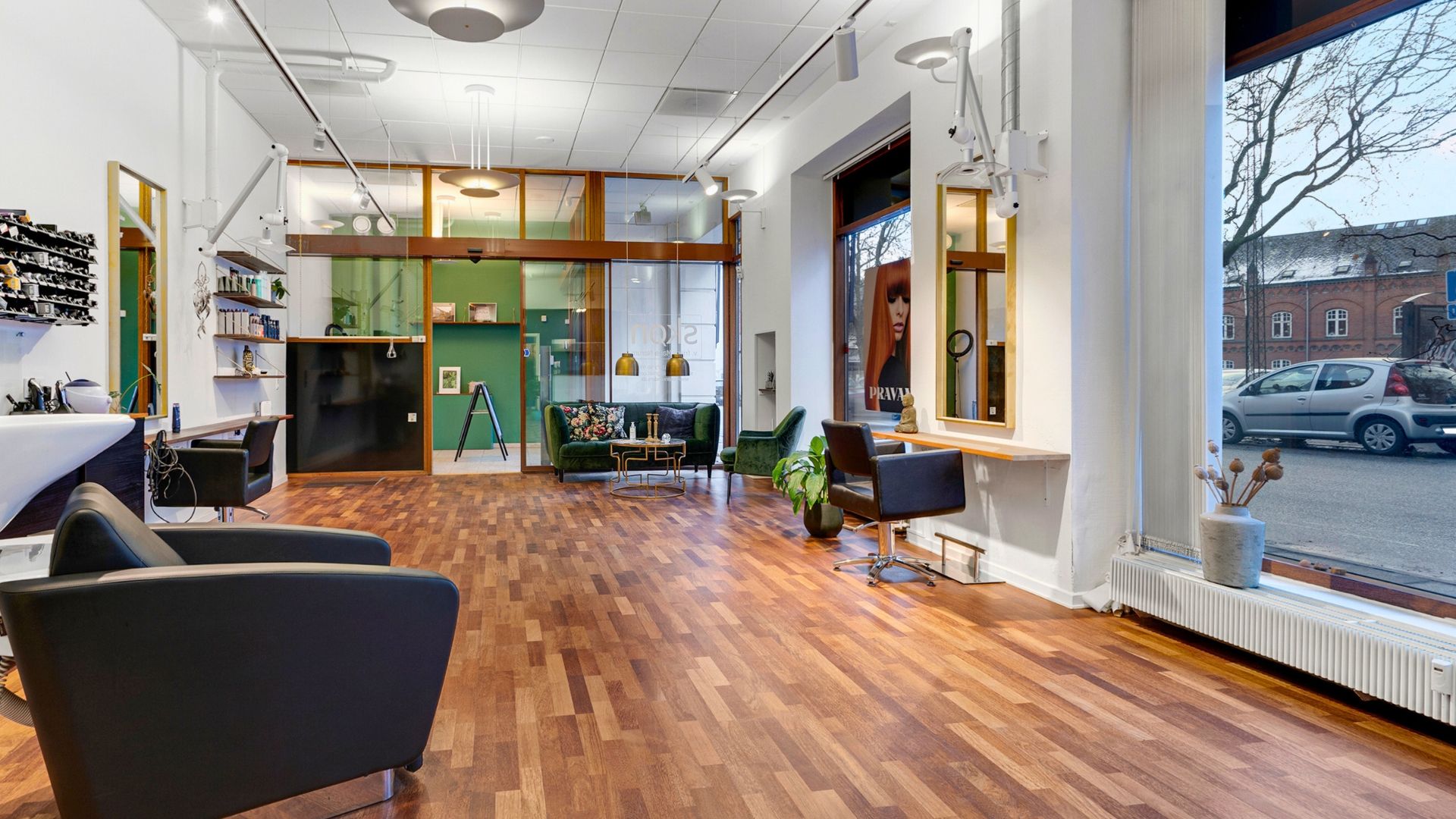 Moderne skab med hylder og opbevaring i salon med trægulv og sofaer og lysekroner