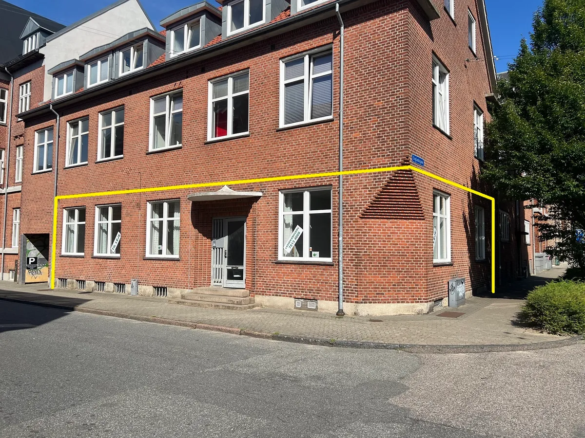 Norgesgade 19, st. i Esbjerg med røde mursten og lyse vinduer samt gule markeringer på siden af bygningen