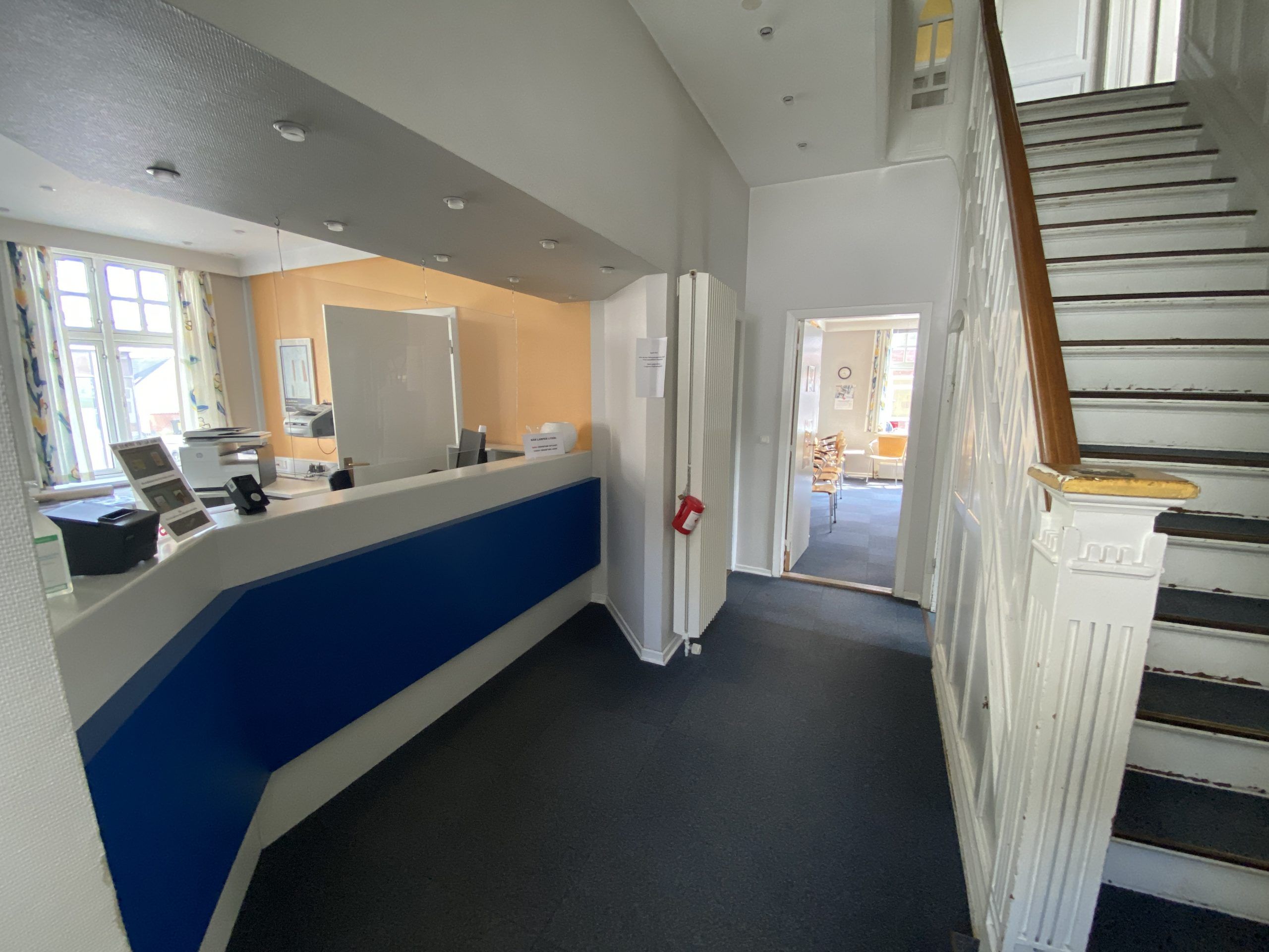 Kontorlokaler med skrivebord, scanner, brandværn og stige til anden etage