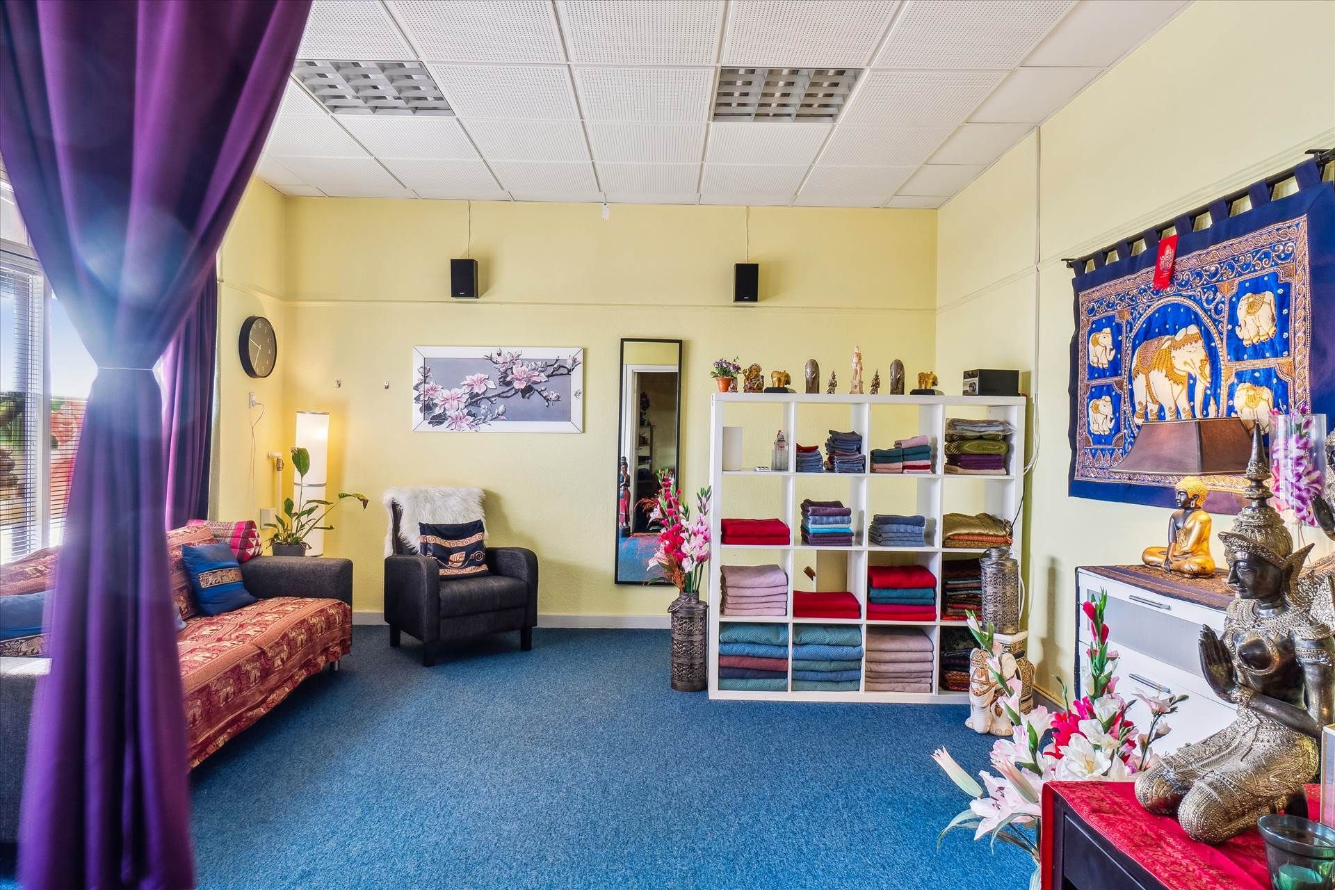 Gulvbelægning og orientalske møbler i lyse lokaler med vindue og gulvbelægning samt udsmykning med tæpper og statuer