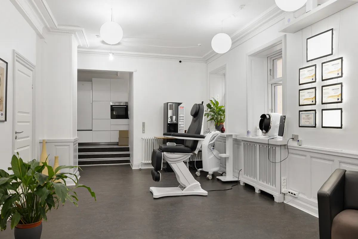 Moderne design med hvidt og sort farveskema, minimalistisk indretning, høj teknologi og ergonomiske stole, kunstig plante og