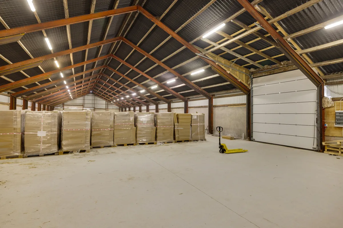 Lagerhal med masser af forskellige pakker og en gaffeltruck parkeret i forgrunden