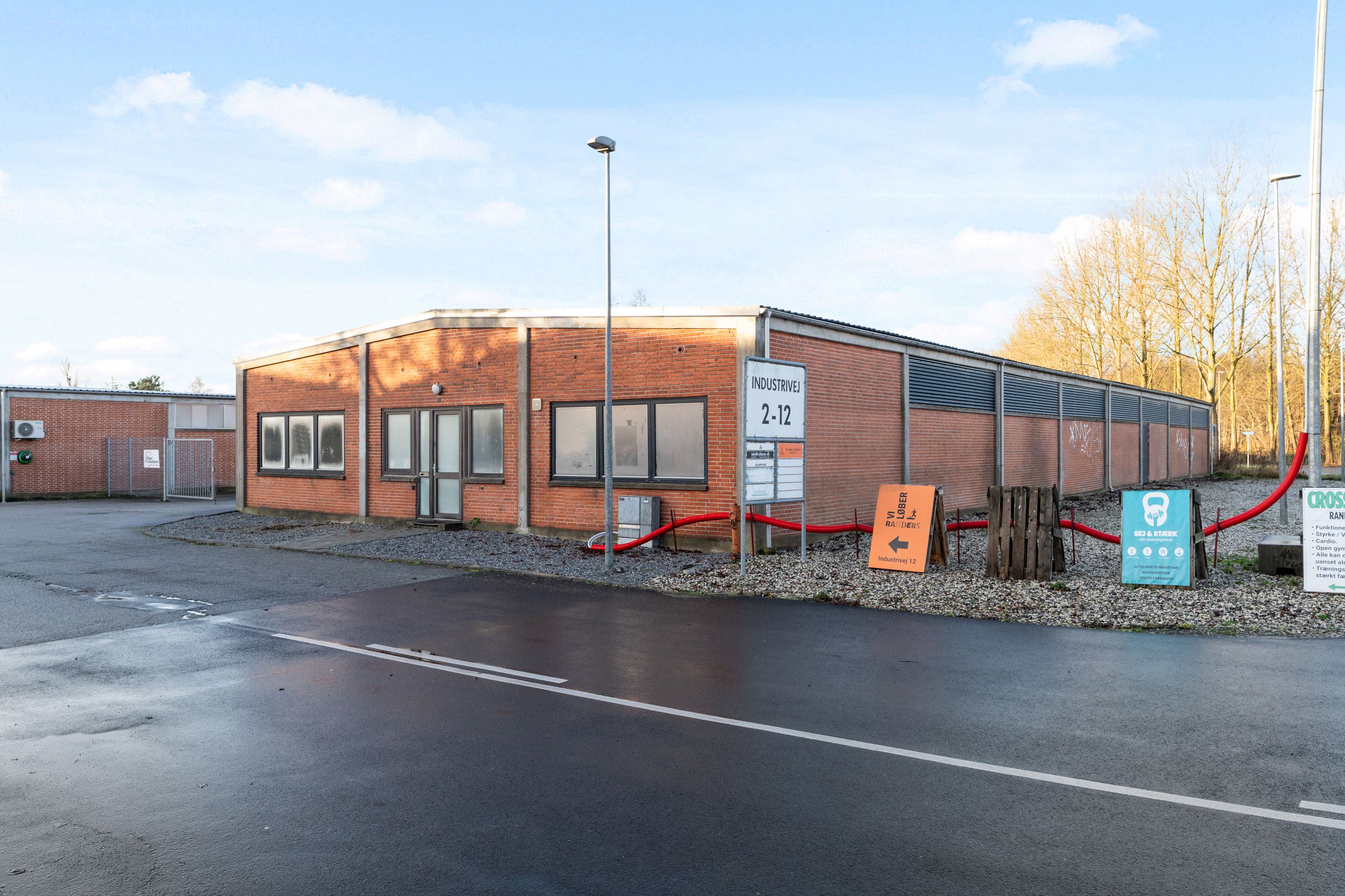 Industribygning med lager og kontorplads til leje på 675 m² og flere faciliteter til træning og motion i baggrunden