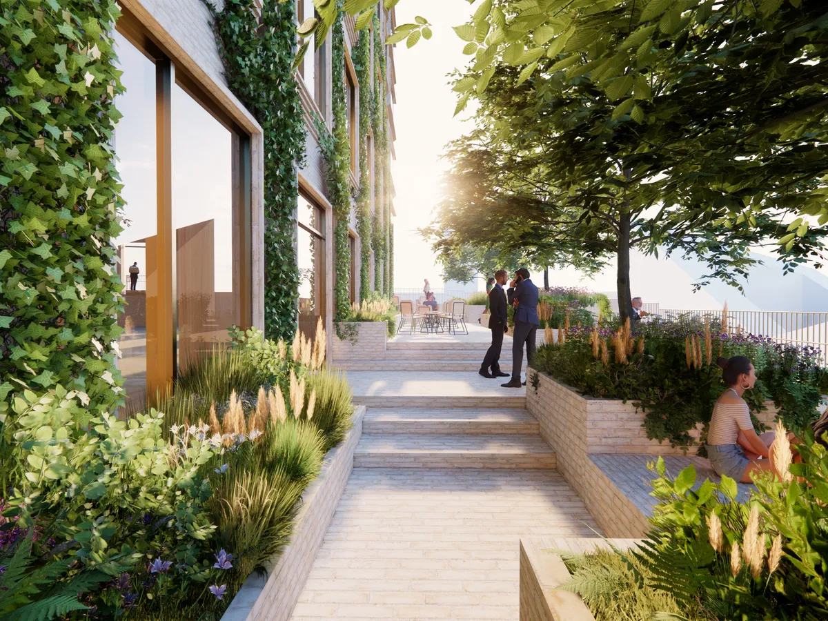 Kontorområde med grønne planter og træer i Aarhus Ø og to mænd i søjerne og kvinde på terrassen