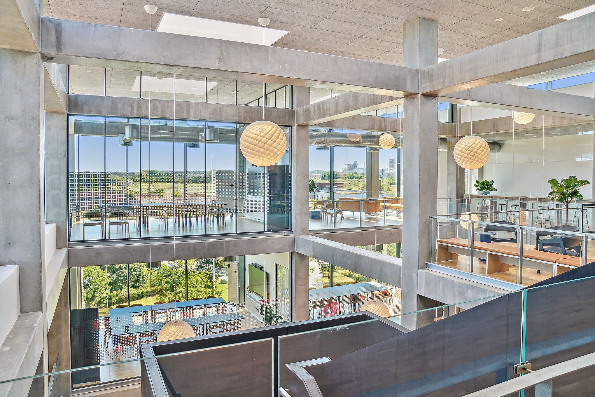 Forretningslokaler med moderne design og mange vinduer med udsigt til grønne områder og bygninger i baggrunden