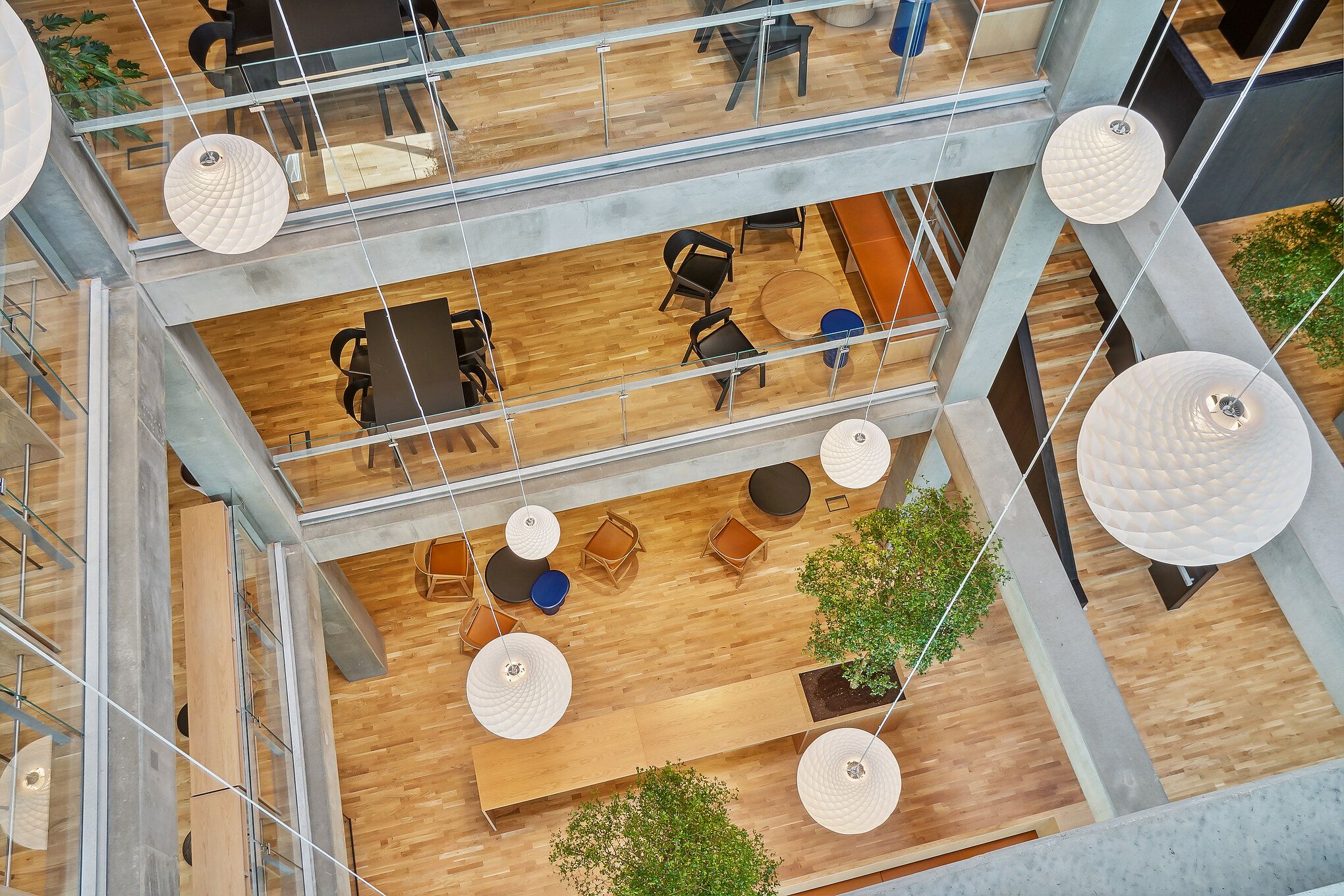 I multietagers erhvervsbygning er der lyse lofter med smukke hængelampe. Her er et åbent område med bord og stole, samt et