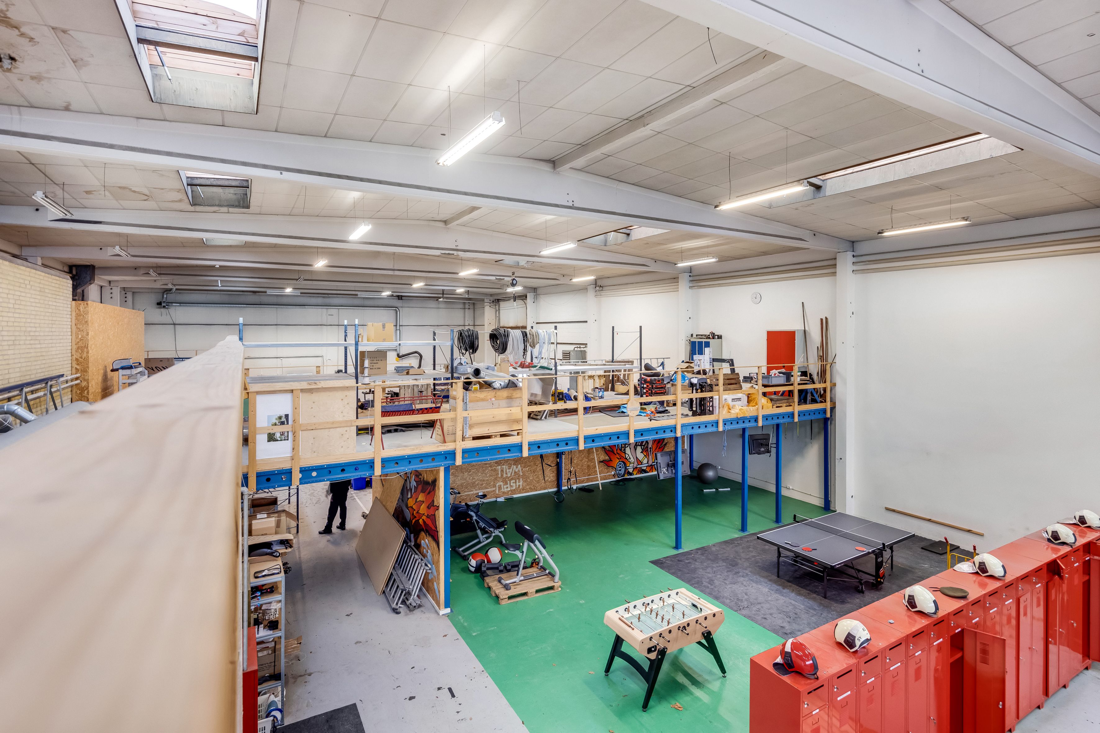 Lejlighed med loftsbåd, pingpongbord, træbordfodbold og hjelme på spindene. Lejligheden har mange lagerhylder og forskellige