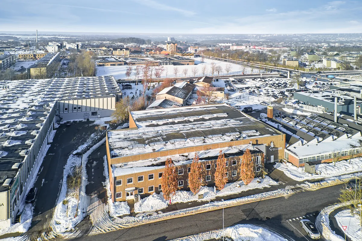 Lejet lager med administrationsbygning og parkeringsplads i centrum af Svendborg. Bygningen er fuldt dækket af sne.