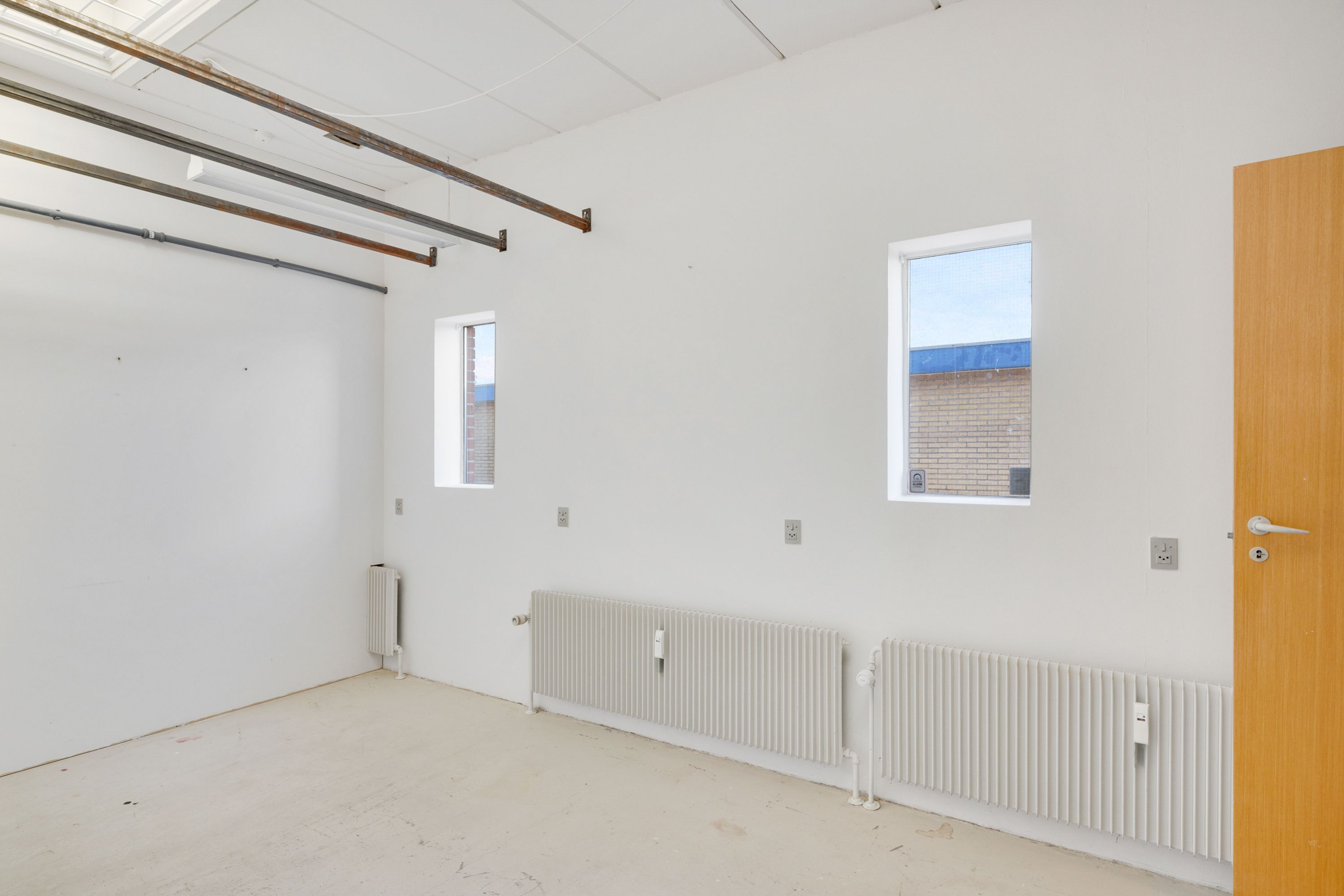 Lejlighed med højloft, nye radiatorer, to vinduer og åben dør til siden med naturligt lys