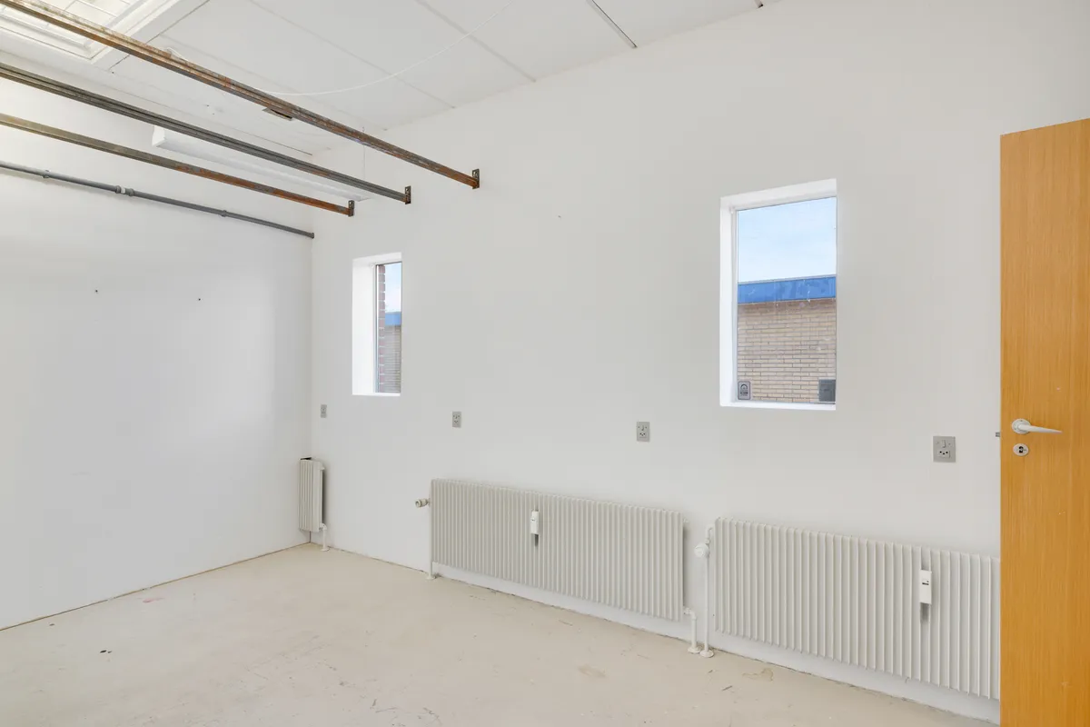 Lejlighed med højloft, nye radiatorer, to vinduer og åben dør til siden med naturligt lys