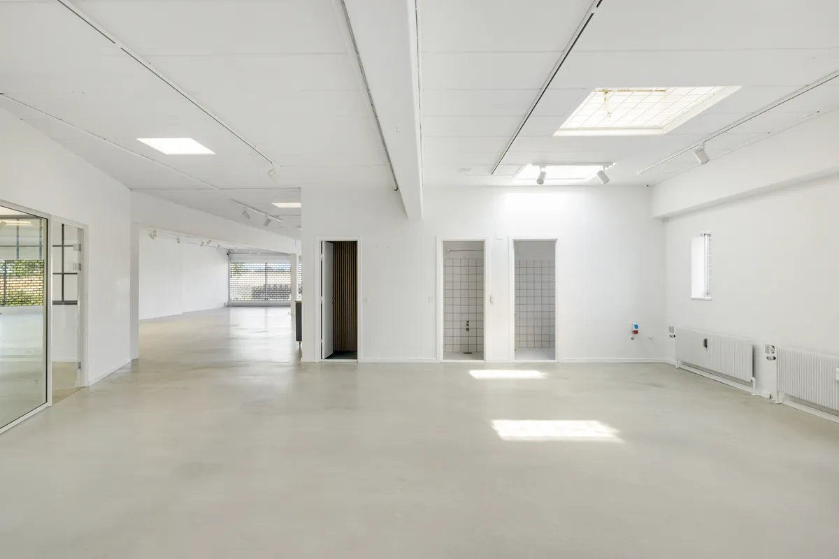 Lejemålet tilbyder store og lyse lokaler med hvide vægge, lysekroner, vindu og spejl, samt to toiletrum og et kontor med et