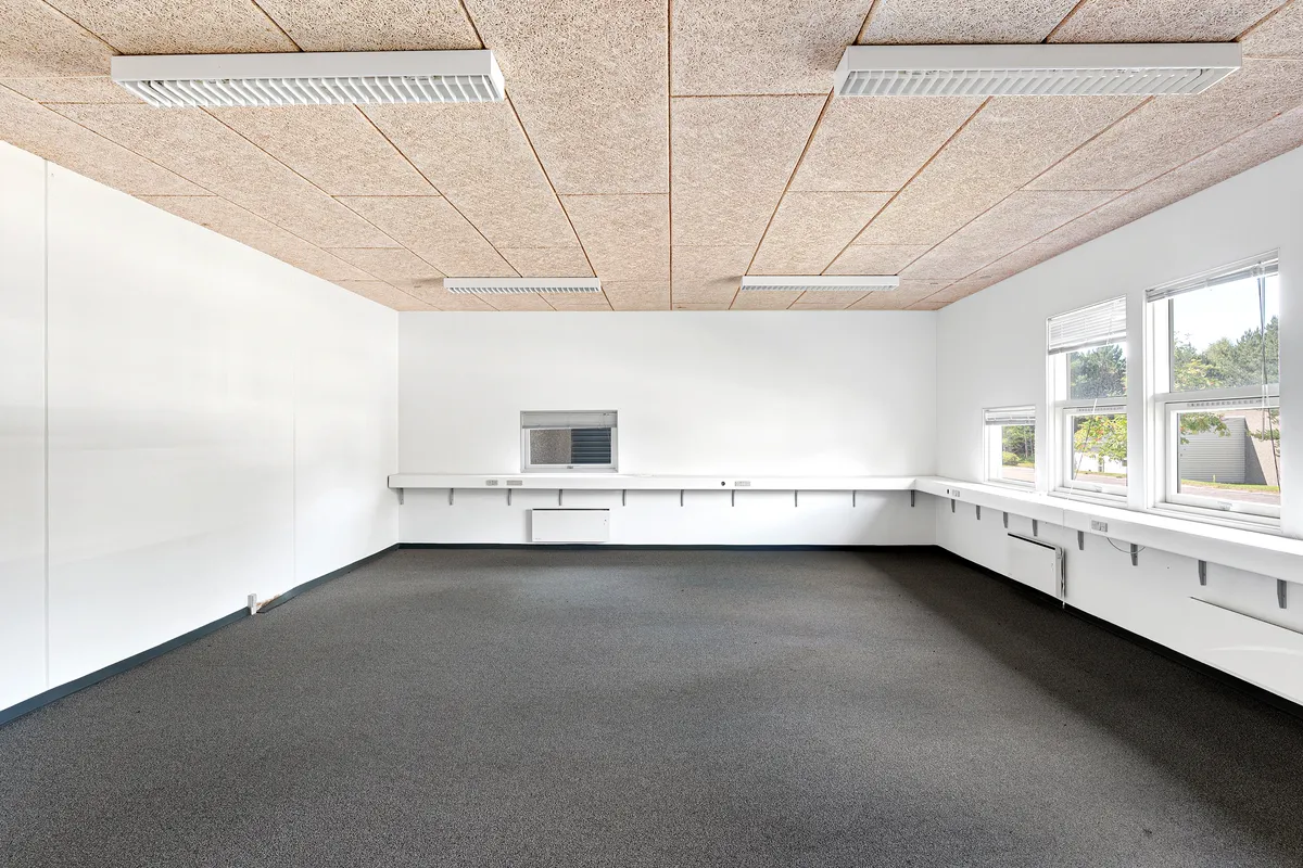 Store, tomme lokaler med hvide vægge, gulv og lofter samt moderne ventilationsinstallationer og fire vinduer til lys og