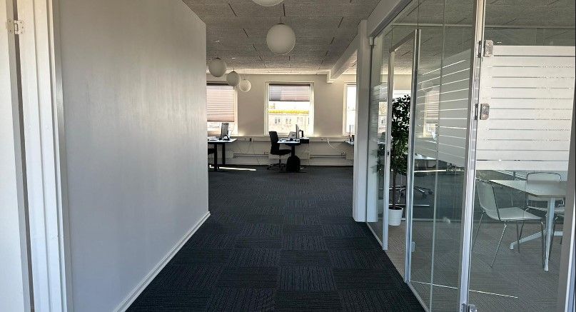 Lyst, nyt og nyistandsat lejemål med moderne møbler og glasvinduer. Moderne kontorlokaler med to skriveborde og computere.