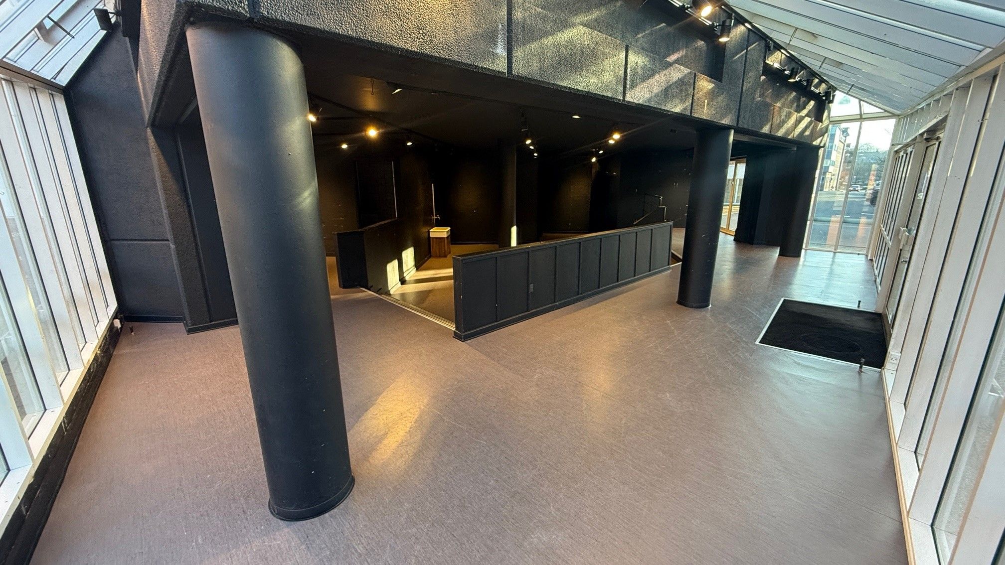 Moderne og minimalistisk lobby med gulvbelægning og lysekroner samt store søjler og vinduer, der giver masser af lys