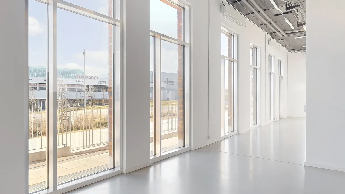 Moderne kontorlokaler med større vinduer og indvendige glasdøre, der giver masser af naturligt lys og en åben følelse i