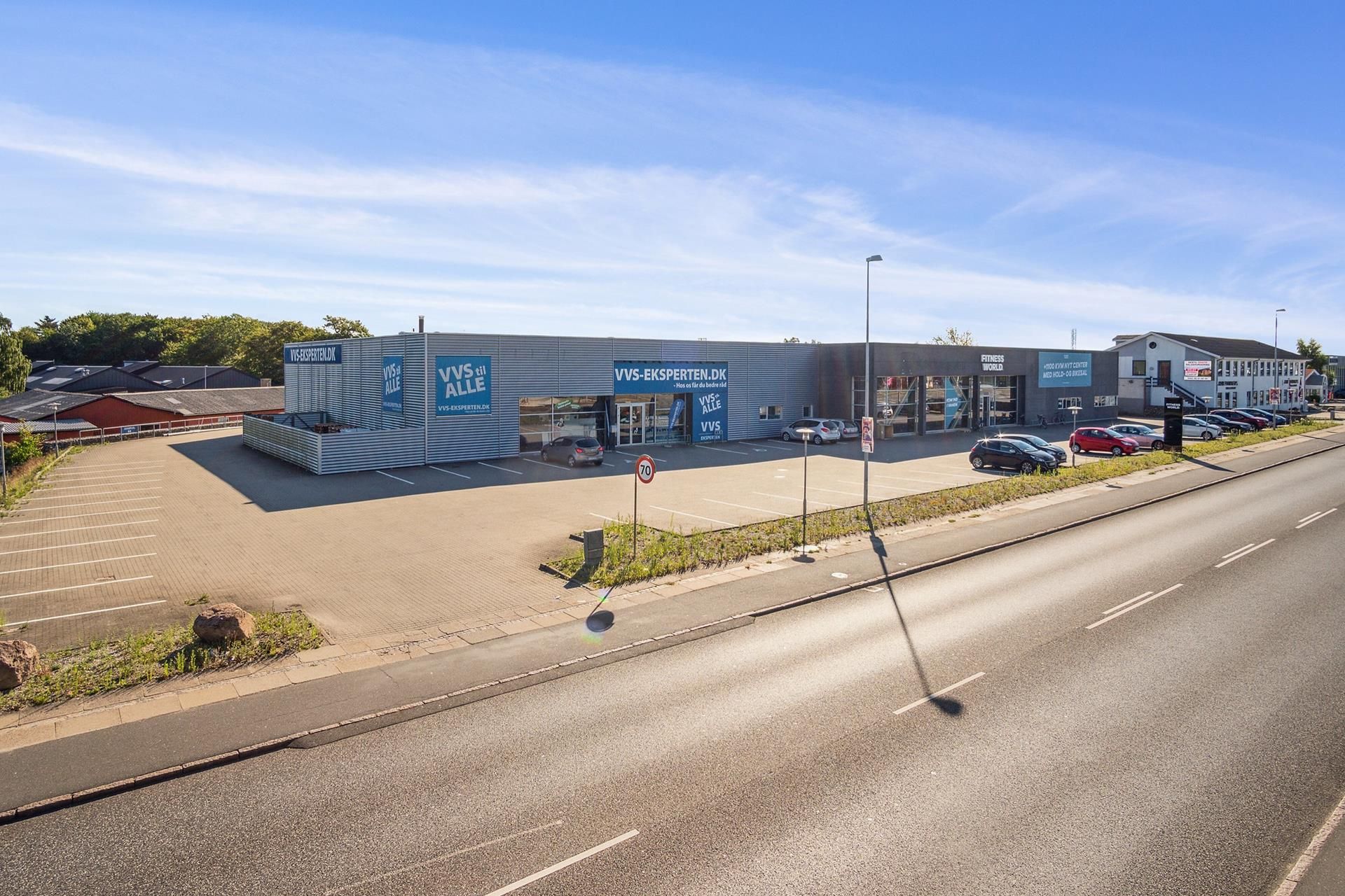 Et lejemål i Randers med flere biler parkeret og et varetegn med teksten "VVS-EKSPERTEN.DK" på facaden