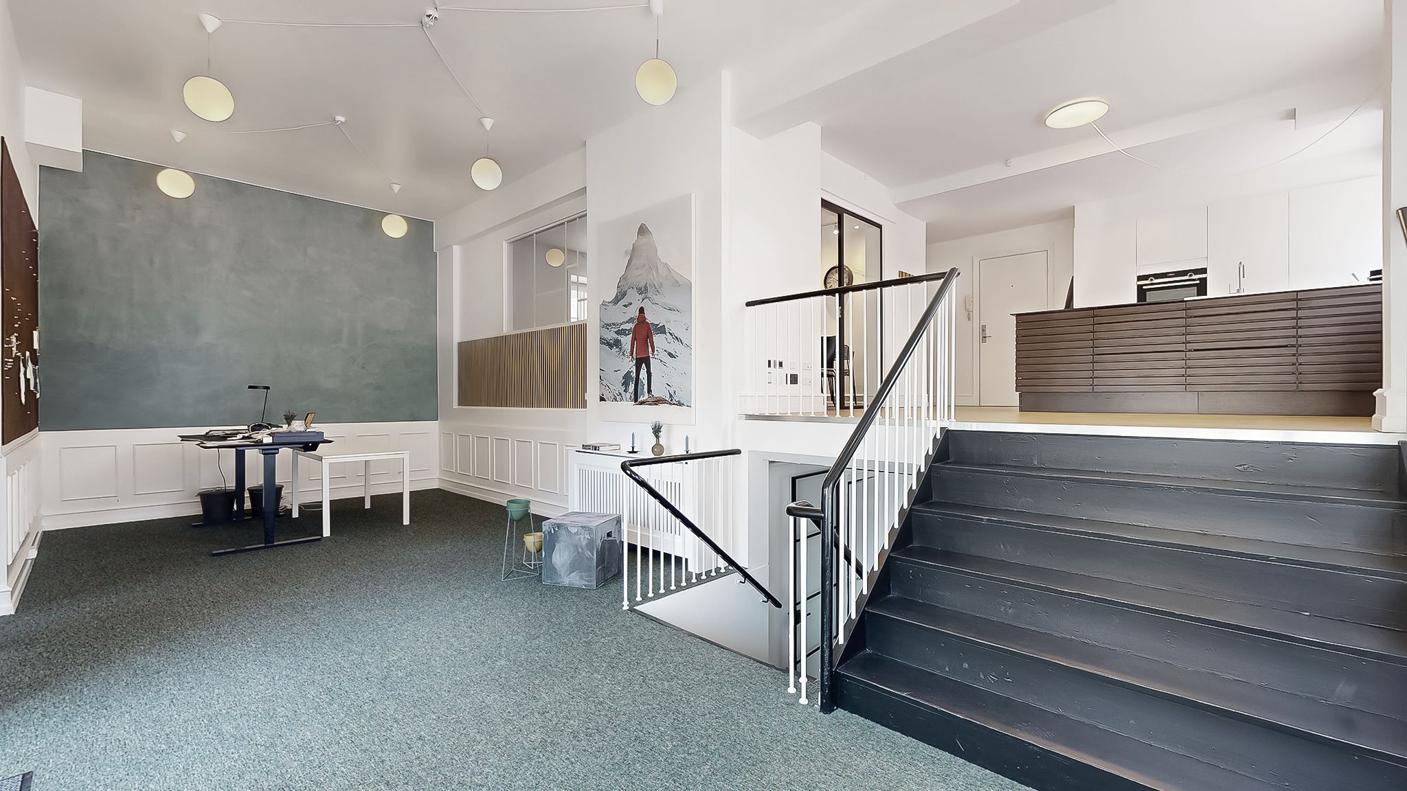 Kontor med højloft, hvidt og gråt gulv, møbler, skrivebord, loftslampe og trappe. Sted med lyse lamper og lysegule vægge.