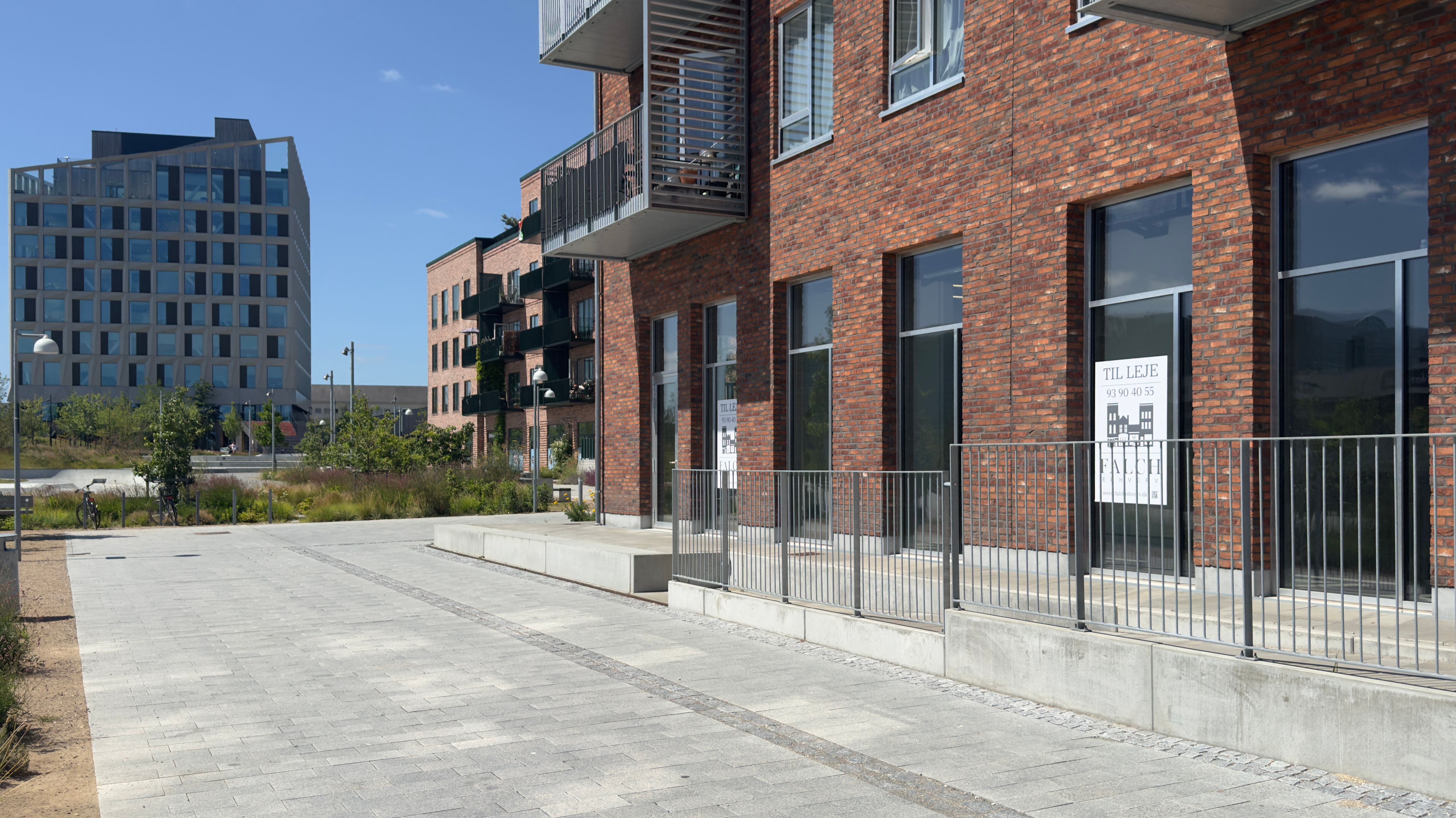 Lejlighedsbygning med moderne design og glasvinduer samt møbeludsalgsskilt på facaden