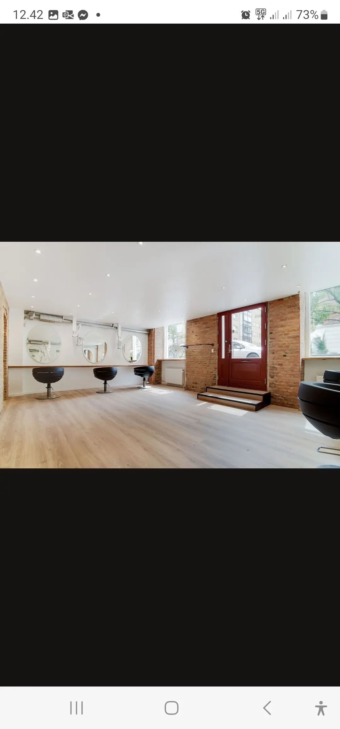 Elegant stue med højt loft og højkvalitets gulvbelægning samt stolpemonterede spejle og lyse træpaneler