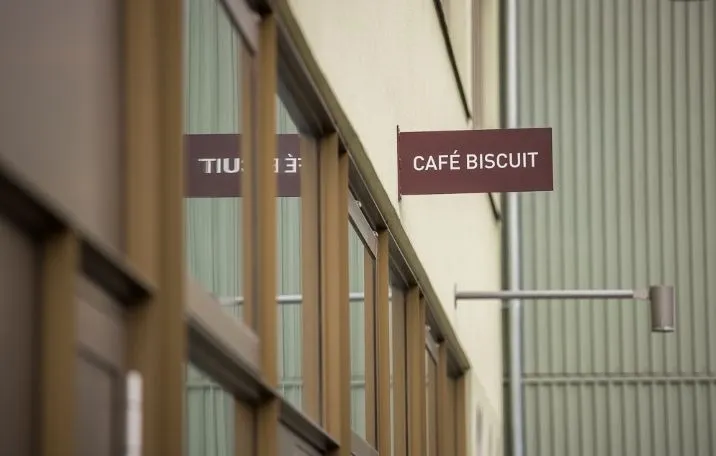 Et slankt kontorlokal med store vinduer og en skilt med teksten Café Biscuit