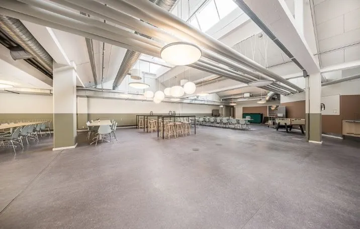 Luksuriøs indretning med lyse lofter, bord og stole, bordfodbold og slanke lysekroner