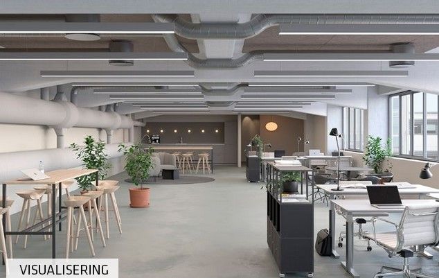 Kontor med åbent layout og lyse lofter, hvor der er stolpeborde, kontormøbler og lyse lamper samt potteplanter og tekniske