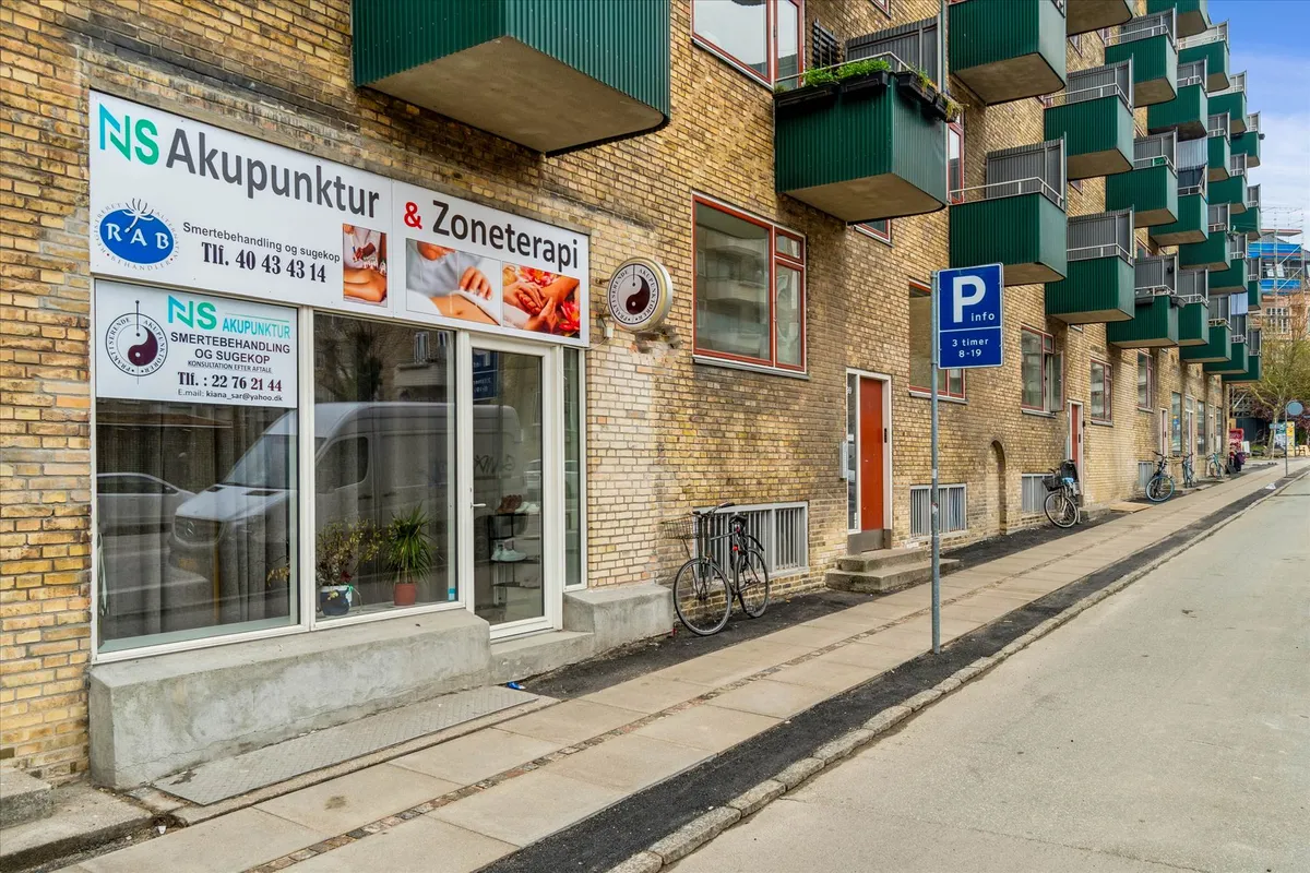 Menighedsbygning med træklatrede facader og en kinesisk massage- og akupunkturklinik i første sal