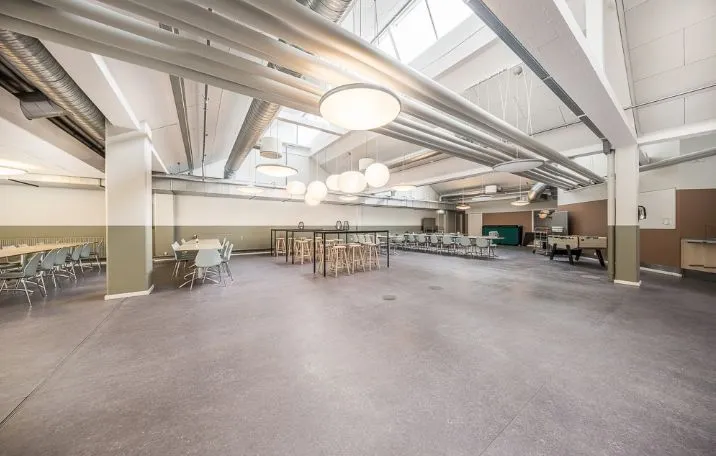 Kontorlokaler med træborde og stole, smuk lysekron og trægulve i en luksuriøs, nyrenoveret lejemål på 1.045 m²